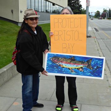 Emily's grandma holds protest signs with a friend during the protest outside the EPA's Anchorage offices.