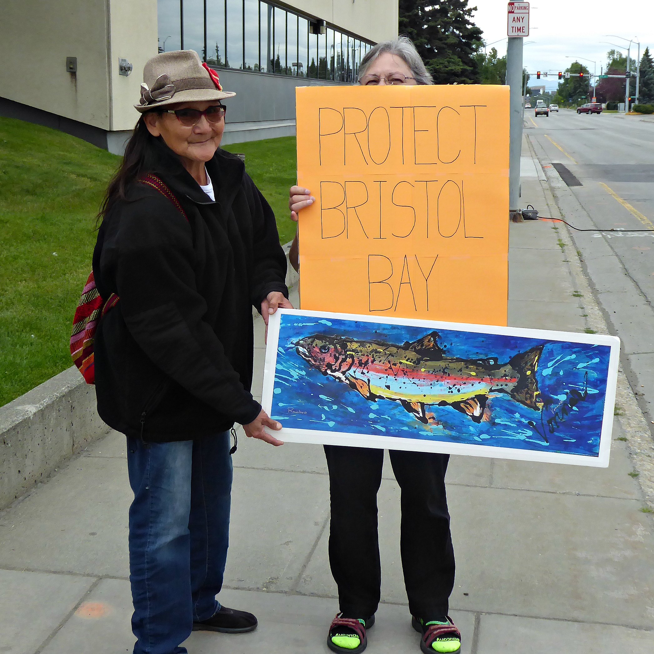 Emily's grandma holds protest signs with a friend during the protest outside the EPA's Anchorage offices.