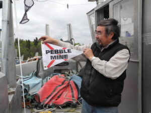 Chief Tom Tilden holding a no Pebble mine flag.