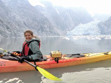 Rachel in a kayak in front of a glacier in Kenai Fjords.
