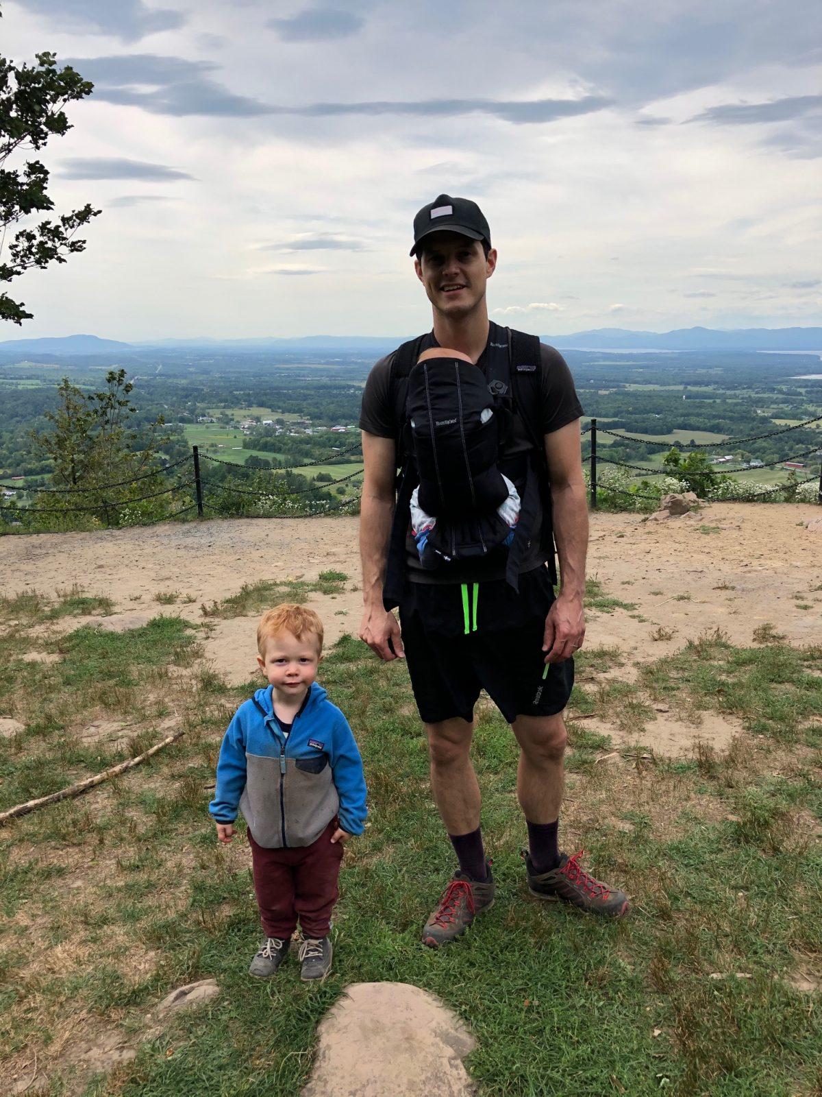 Carl and his kids on a hill with sky in the background in Vermont, 2020