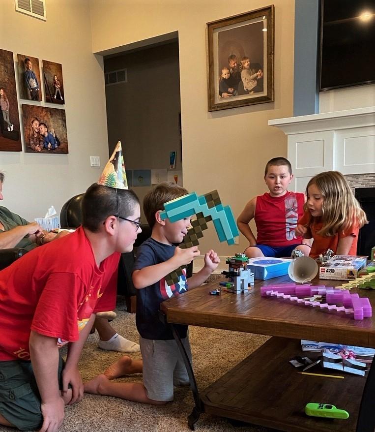 On happiness (and social skills). Kids play with building toys at a coffee table in a room with kid portraits on the walls.